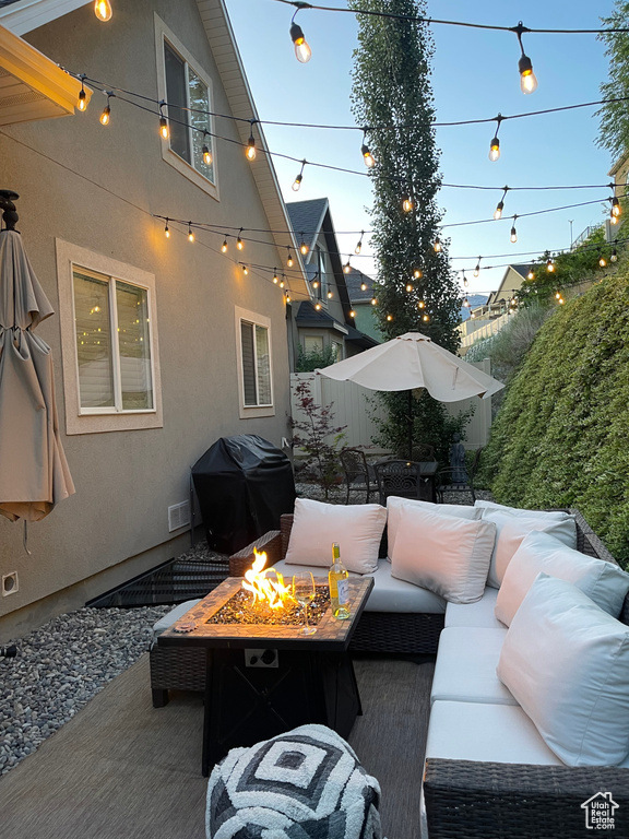 View of patio featuring a grill and an outdoor living space with a fire pit