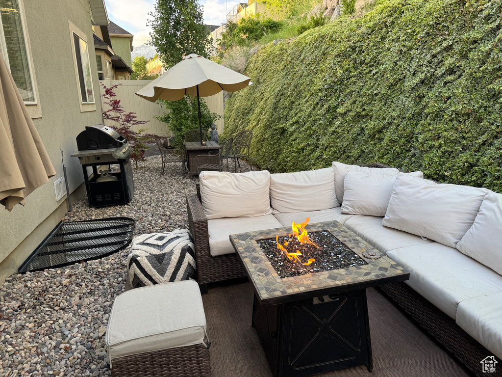 View of patio with an outdoor living space with a fire pit and area for grilling