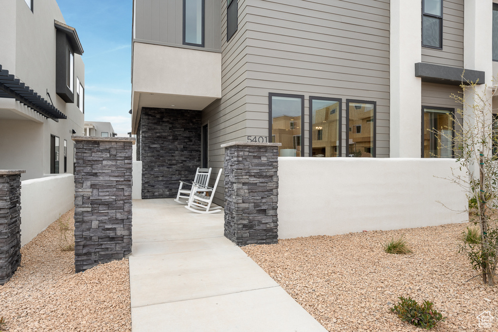 Doorway to property with a porch and stone siding