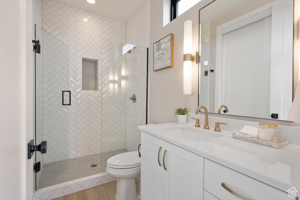Full bathroom with a shower stall, toilet, and vanity
