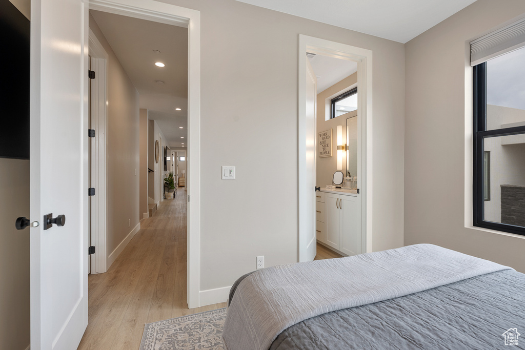 Bedroom featuring ensuite bath, recessed lighting, baseboards, and light wood-style floors