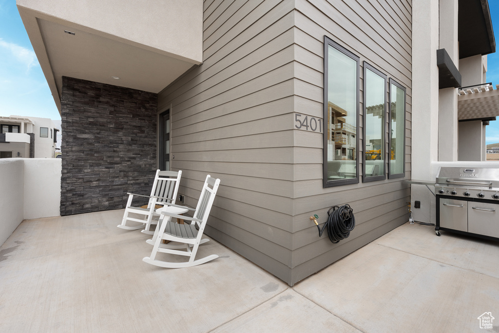View of patio with a grill