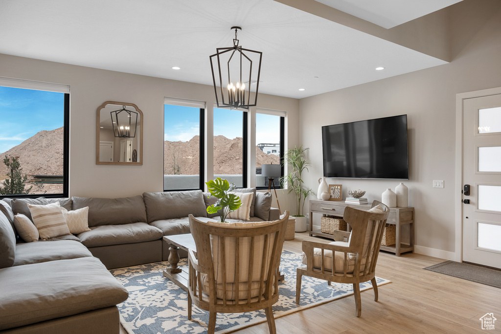 Living area featuring light wood finished floors, baseboards, recessed lighting, a notable chandelier, and a mountain view
