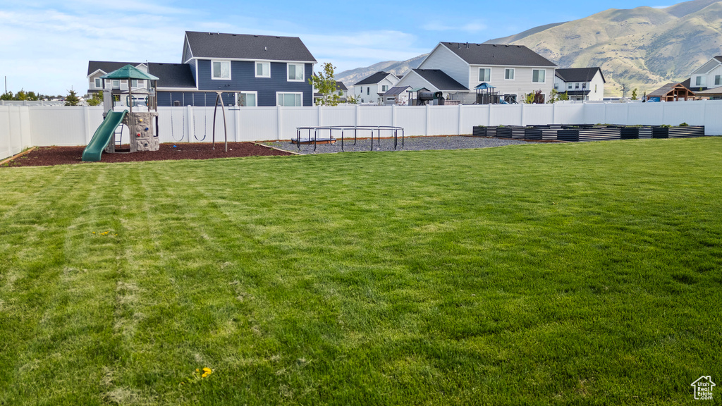 View of yard with a playground, a mountain view, and a residential view