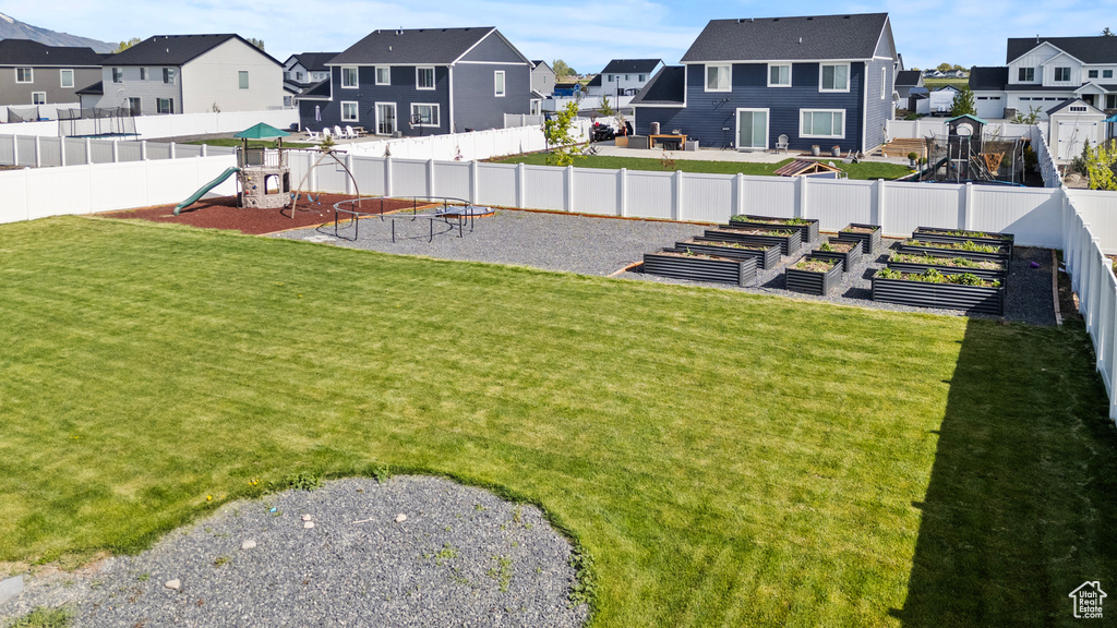 View of yard featuring a residential view, a vegetable garden, and a playground