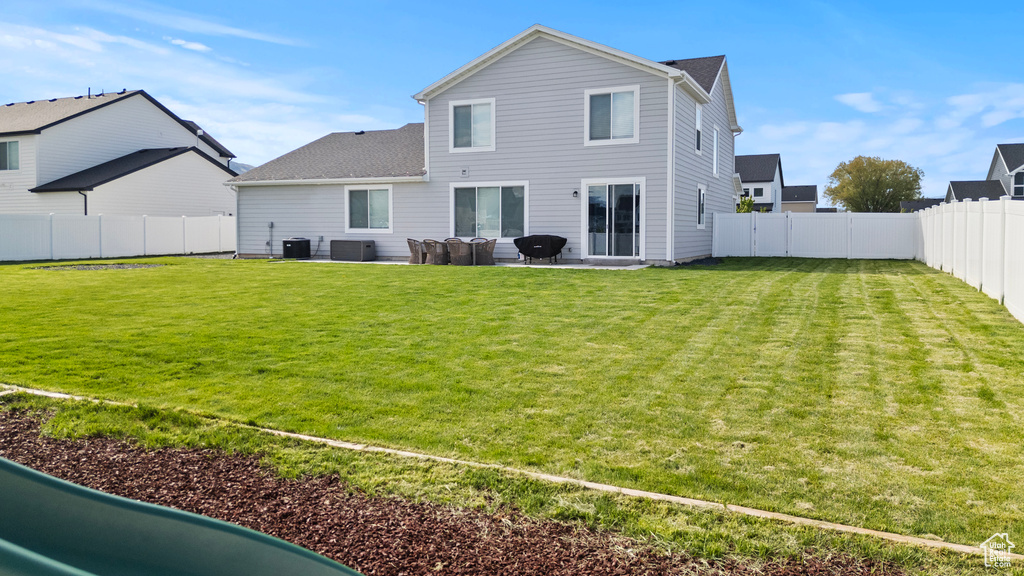 Rear view of house with a patio, central AC unit, and roof with shingles