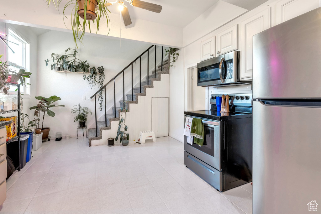 Kitchen with white cabinetry, a ceiling fan, and stainless steel appliances