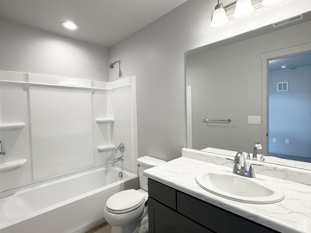 Full bathroom with vanity, toilet, washtub / shower combination, and visible vents