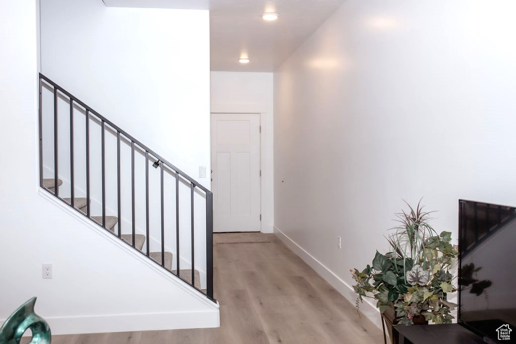 Staircase with wood finished floors and baseboards