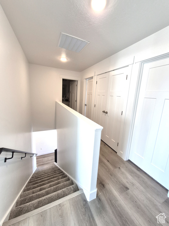 Stairs with visible vents and wood finished floors