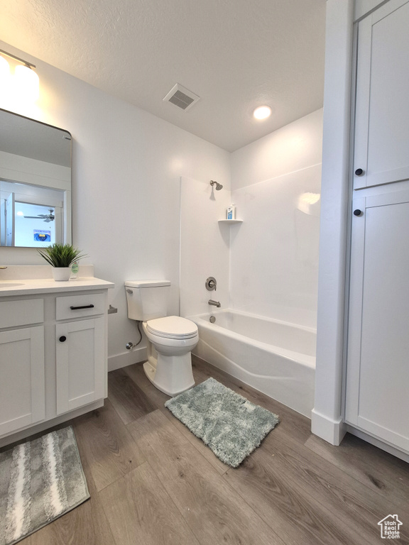 Full bathroom with visible vents, toilet, wood finished floors, bathtub / shower combination, and vanity