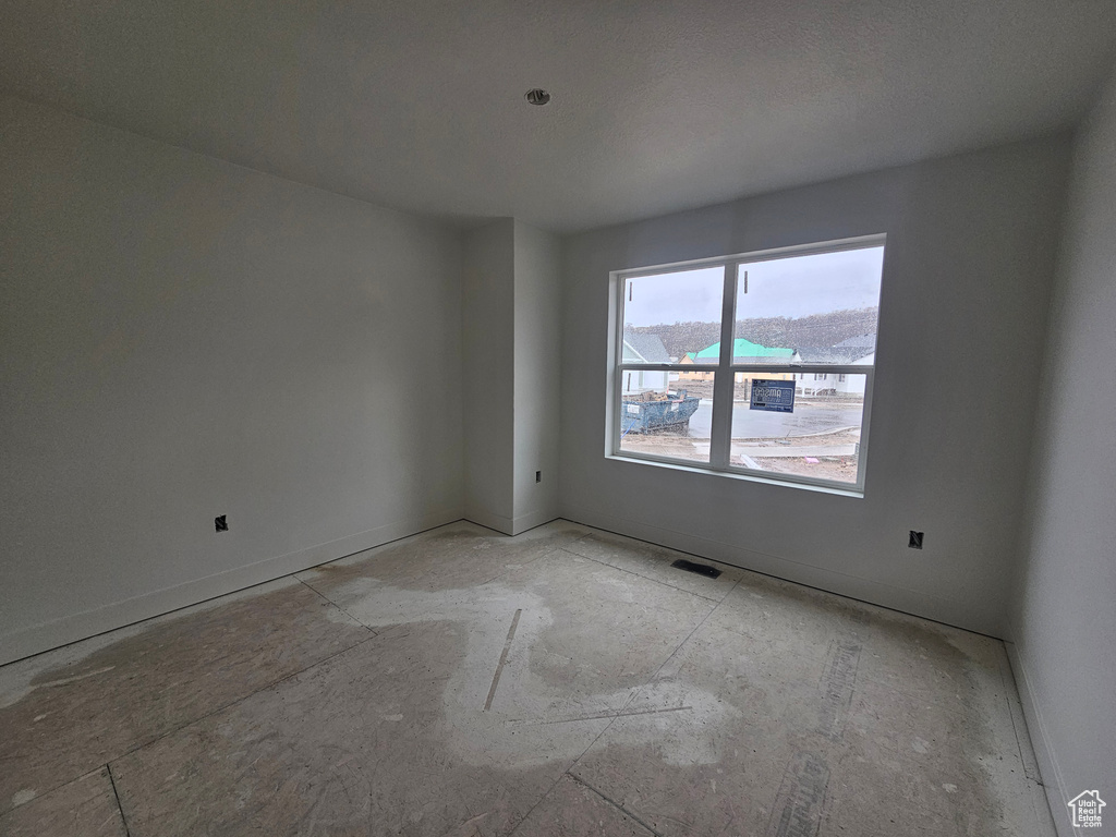Unfurnished room featuring visible vents and baseboards