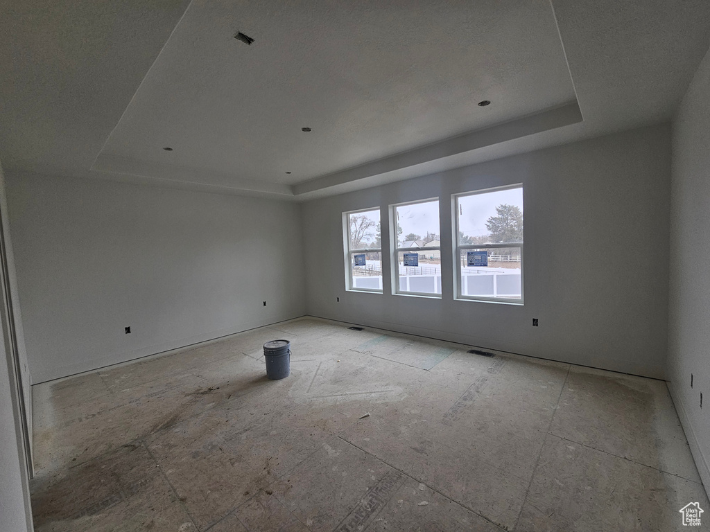 Unfurnished room with a tray ceiling and visible vents