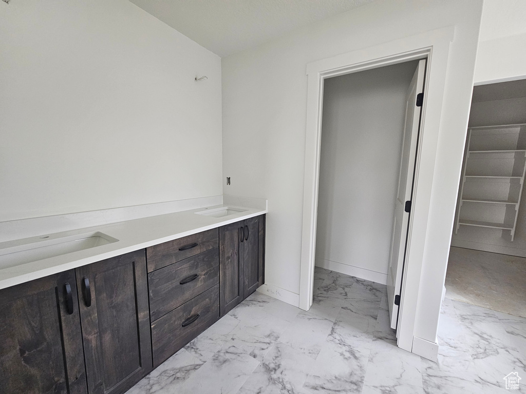 Bathroom with a sink, baseboards, and marble finish floor