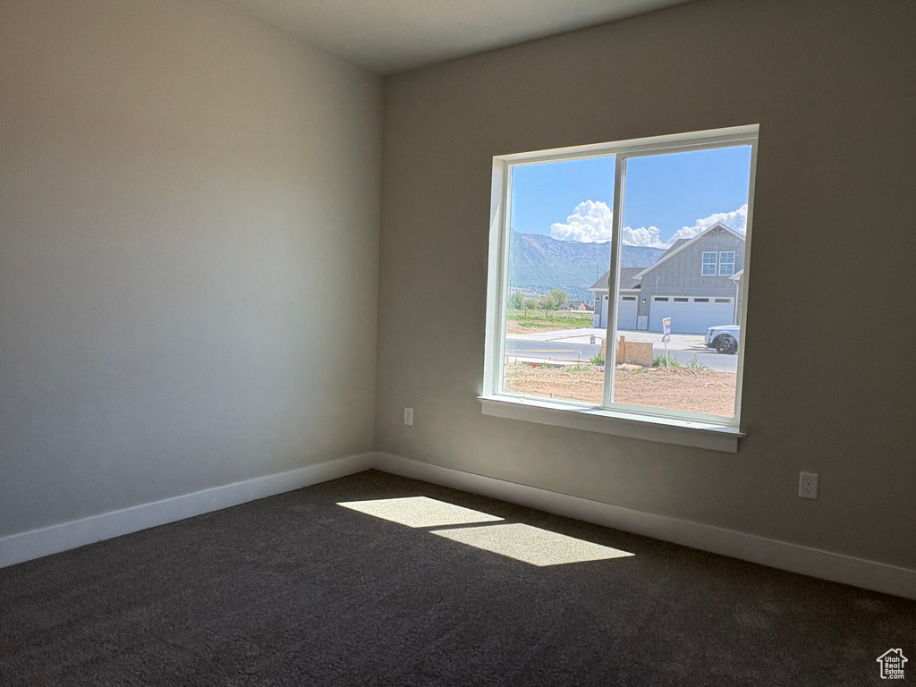 Unfurnished room featuring healthy amount of natural light, carpet, and baseboards