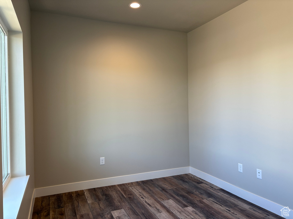 Empty room with recessed lighting, baseboards, and dark wood-style floors