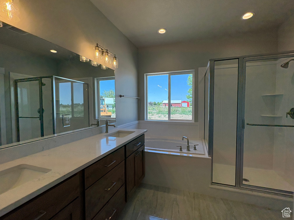 Bathroom with a stall shower, a bath, recessed lighting, and double vanity