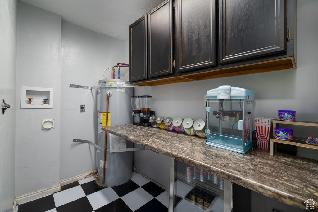 Washroom featuring hookup for an electric dryer, laundry area, washer hookup, electric water heater, and dark floors