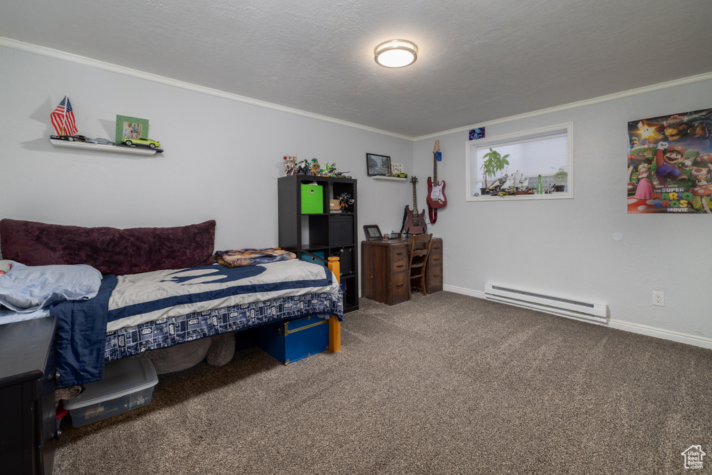 Bedroom with a baseboard radiator, a textured ceiling, ornamental molding, and carpet flooring