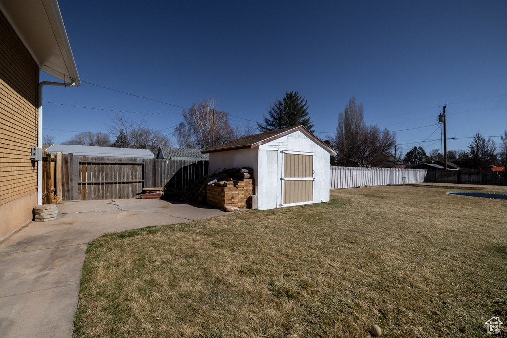 View of yard with an outbuilding, a patio, a storage shed, and a fenced backyard