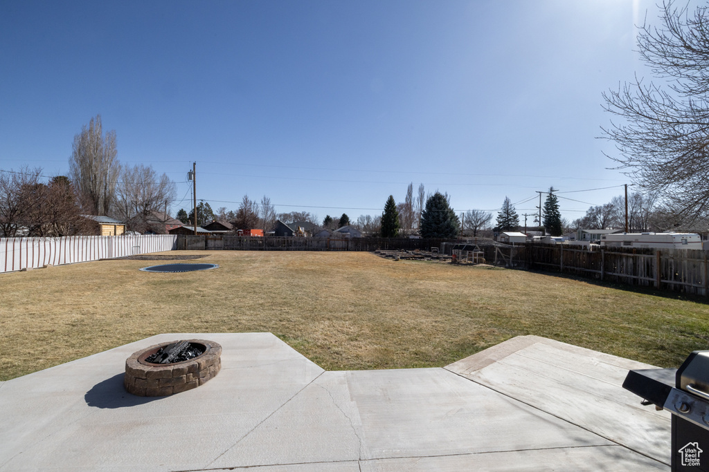 View of yard featuring an outdoor fire pit, a fenced backyard, and a patio area