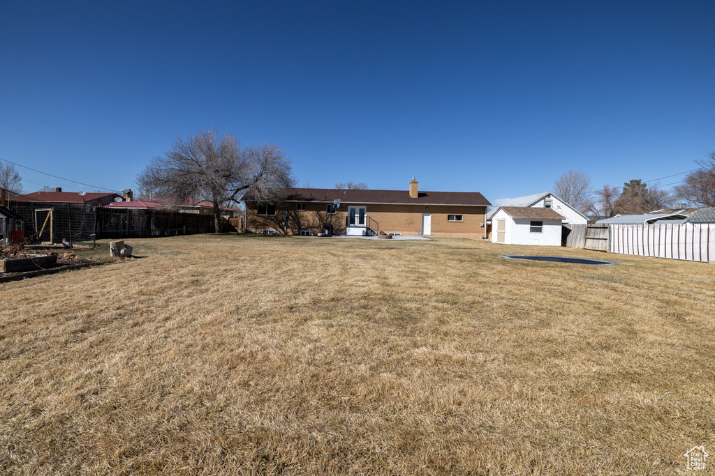 View of yard with a storage unit, an outdoor structure, and fence