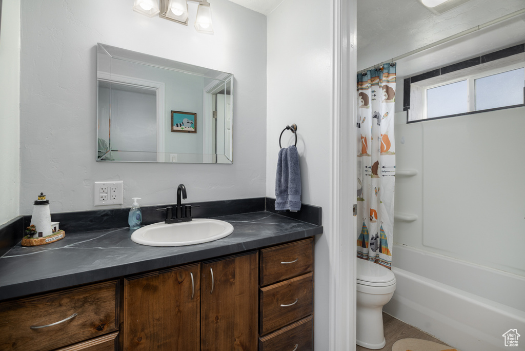 Bathroom featuring vanity, toilet, and shower / bath combo