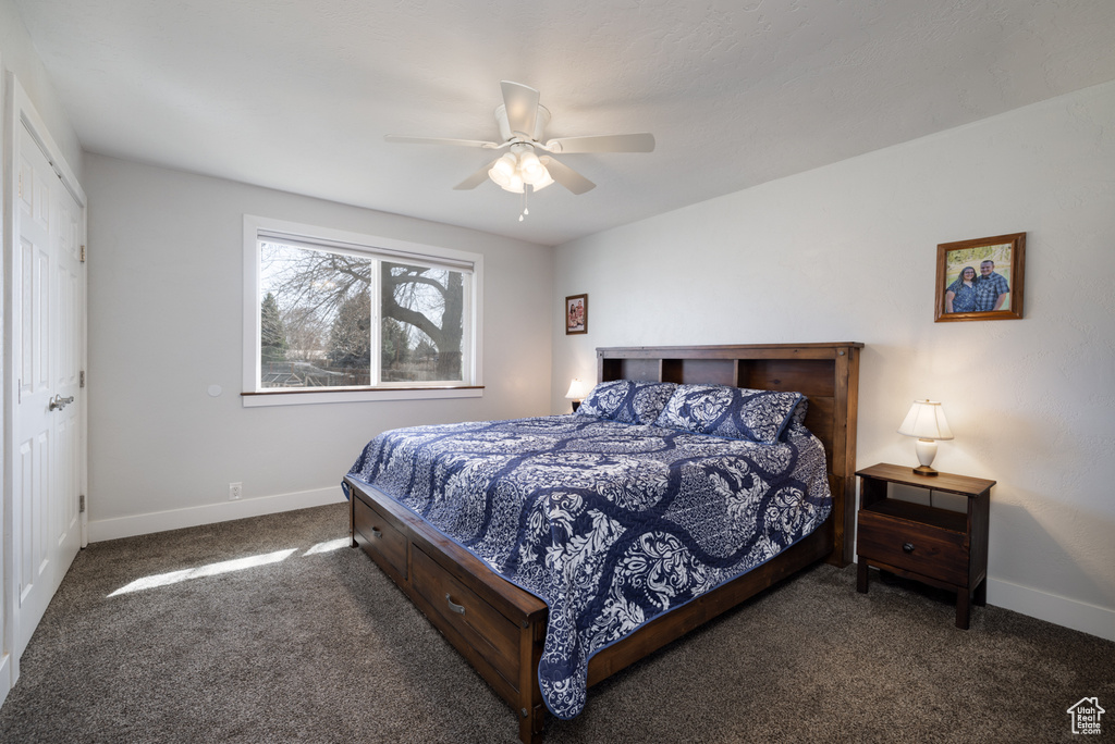 Bedroom with a ceiling fan, baseboards, and carpet floors