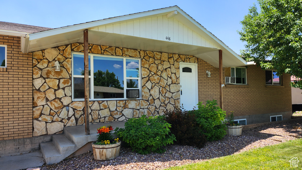 View of front facade with stone siding, crawl space, and brick siding