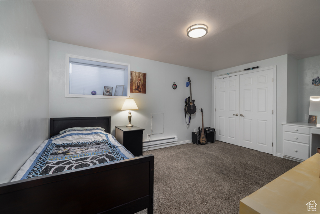 Bedroom featuring a closet, baseboards, carpet, and a baseboard radiator