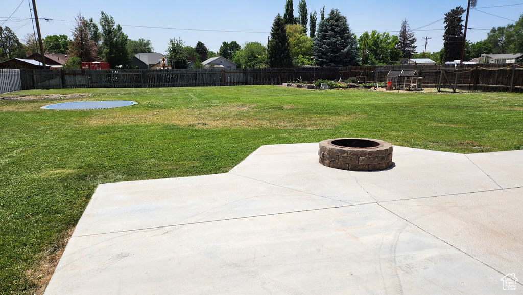 Fenced backyard featuring an outdoor fire pit and a patio area