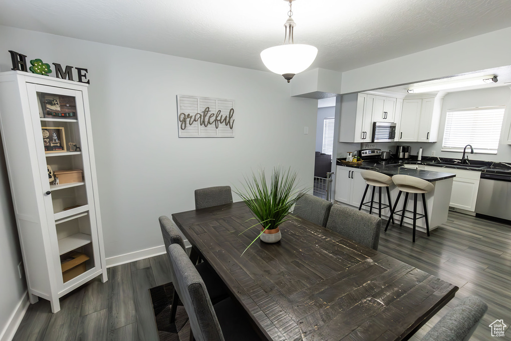 Dining space featuring dark wood finished floors and baseboards