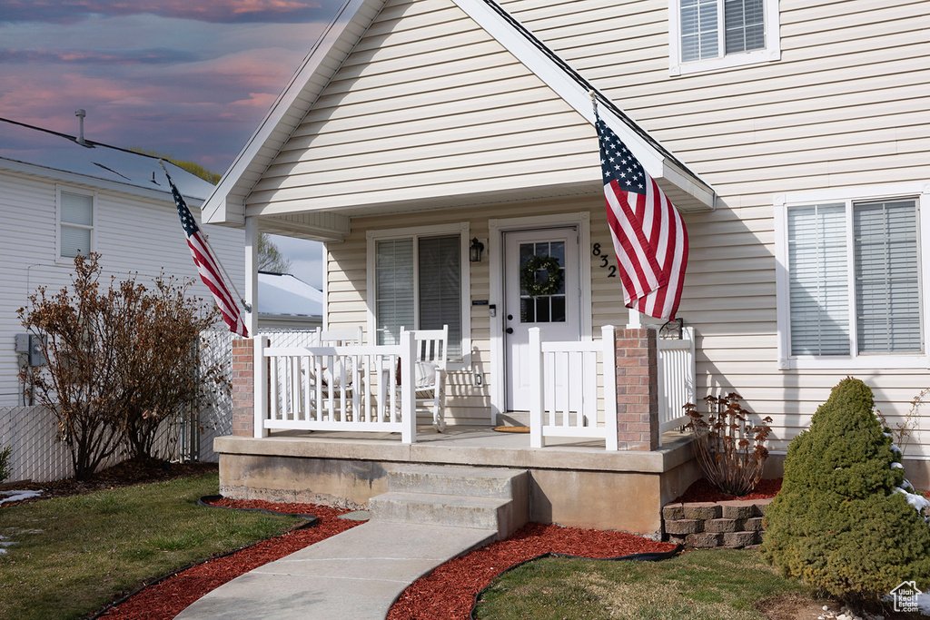 Exterior entry at dusk featuring a porch
