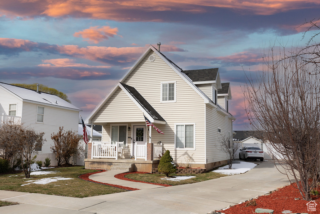 View of front of property with covered porch, driveway, and roof with shingles
