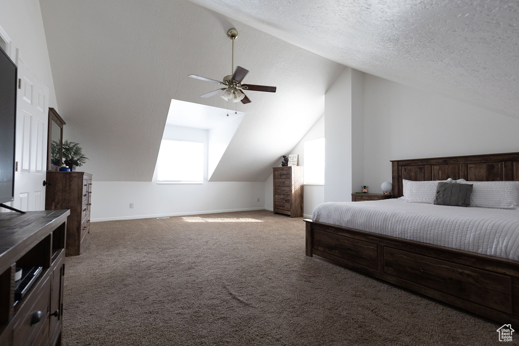 Carpeted bedroom featuring baseboards, a textured ceiling, lofted ceiling, and a ceiling fan