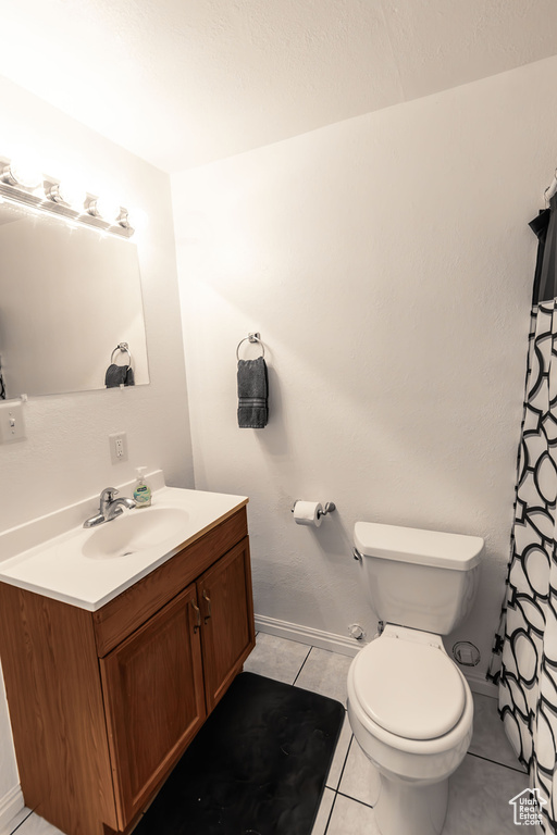 Full bath featuring tile patterned flooring, toilet, vanity, and baseboards