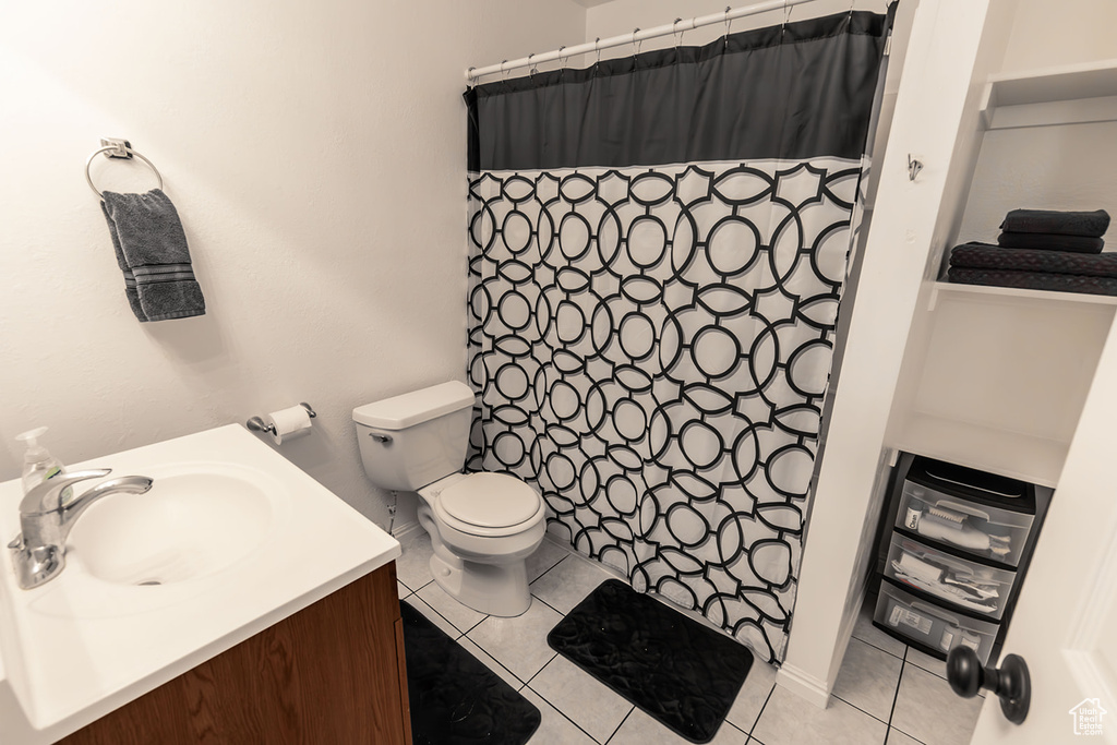 Bathroom with tile patterned flooring, a shower with shower curtain, toilet, and vanity