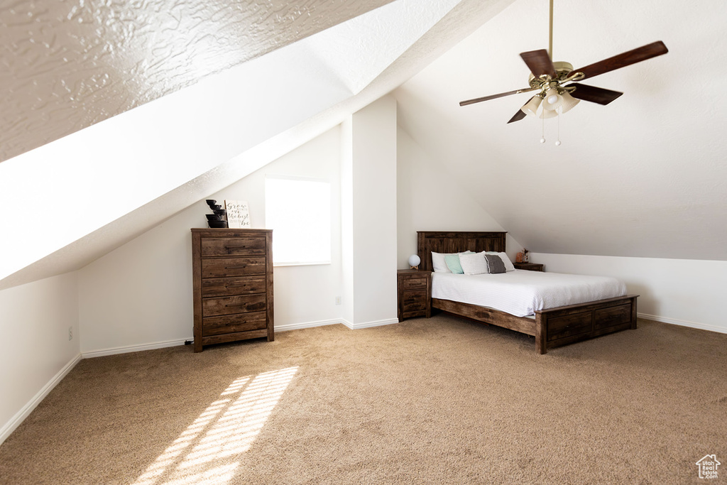 Unfurnished bedroom with vaulted ceiling, carpet flooring, baseboards, and ceiling fan