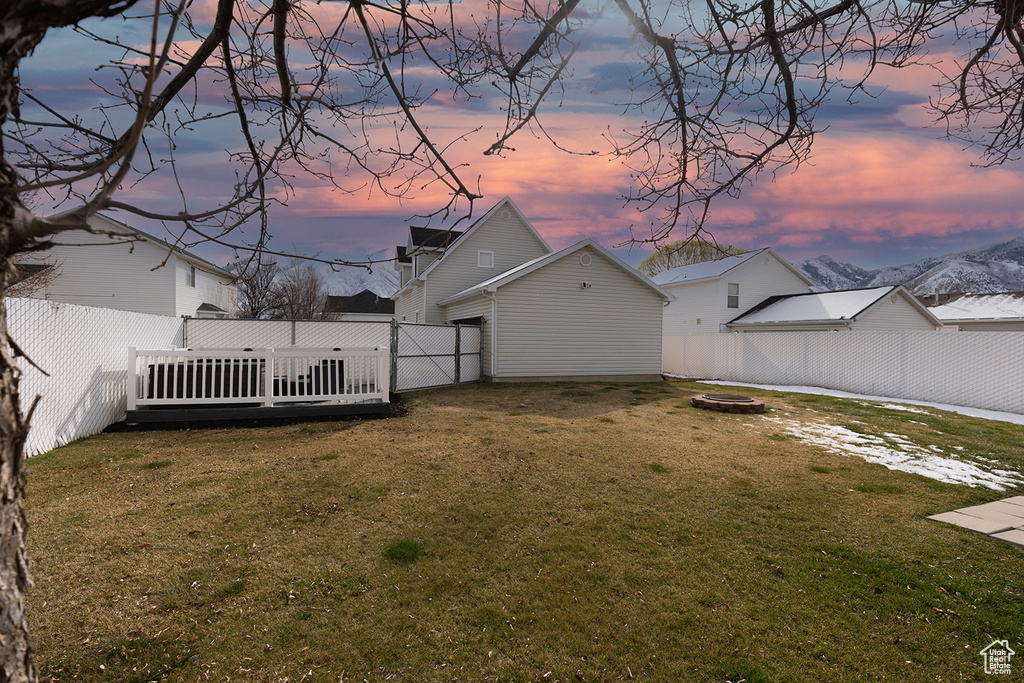 Yard at dusk with a fenced backyard and a fire pit