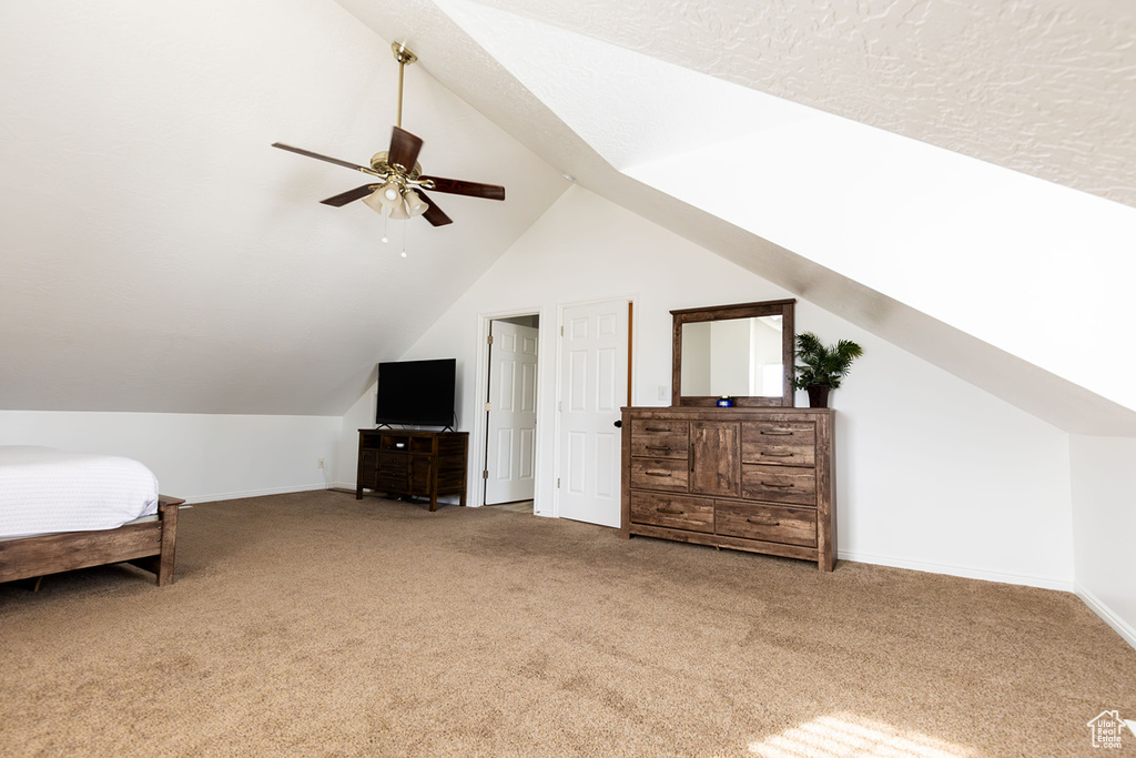 Carpeted bedroom with baseboards, a ceiling fan, and vaulted ceiling