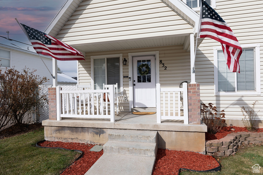 Doorway to property featuring covered porch