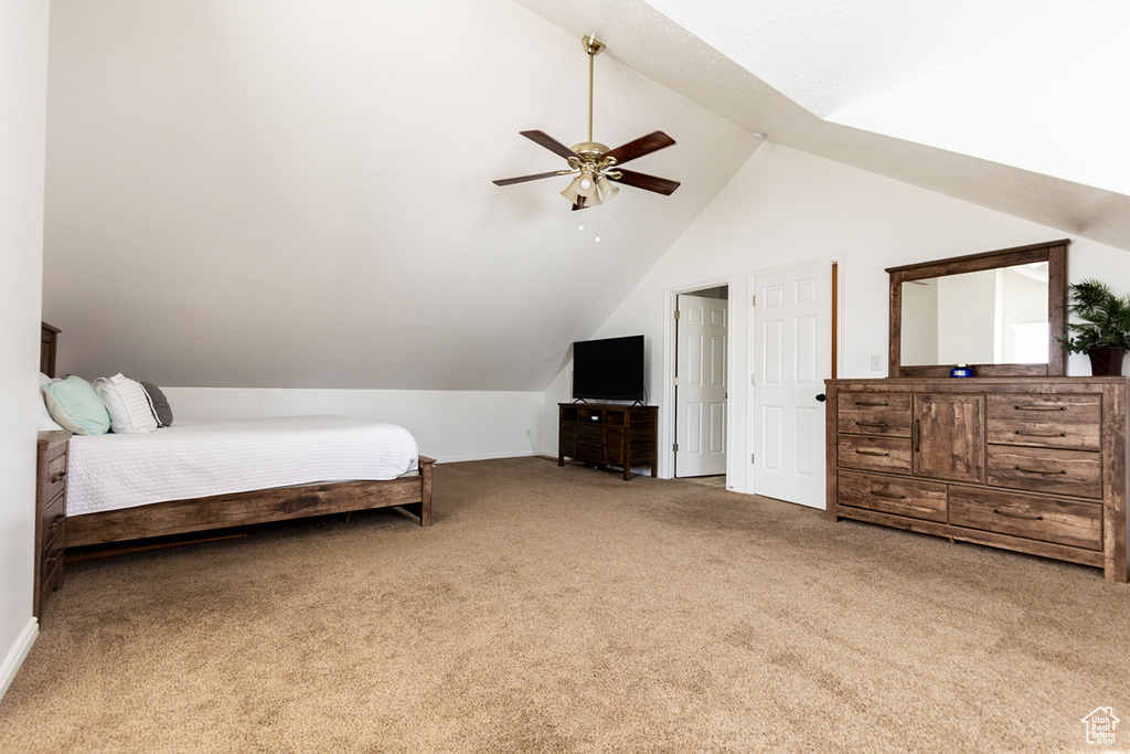 Carpeted bedroom featuring vaulted ceiling and ceiling fan