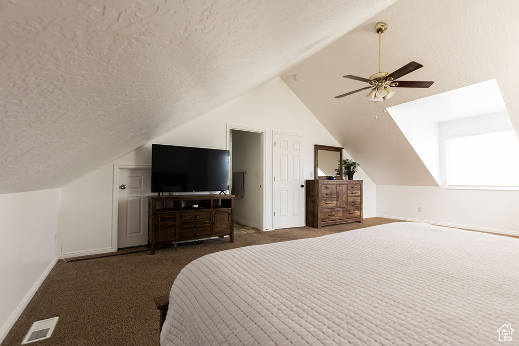 Carpeted bedroom with baseboards, a textured ceiling, lofted ceiling, and ceiling fan