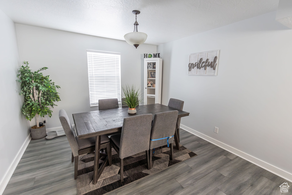 Dining room with dark wood finished floors and baseboards