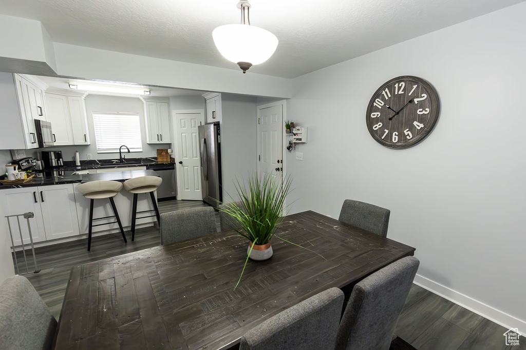 Dining area with dark wood-style floors and baseboards