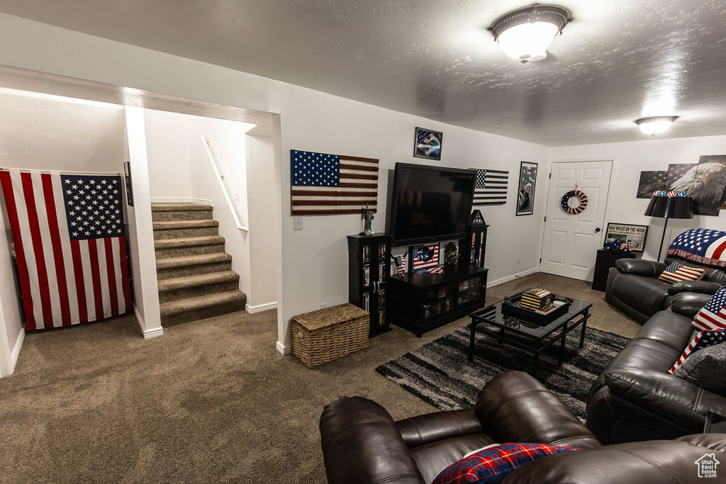 Carpeted living area with baseboards and stairs