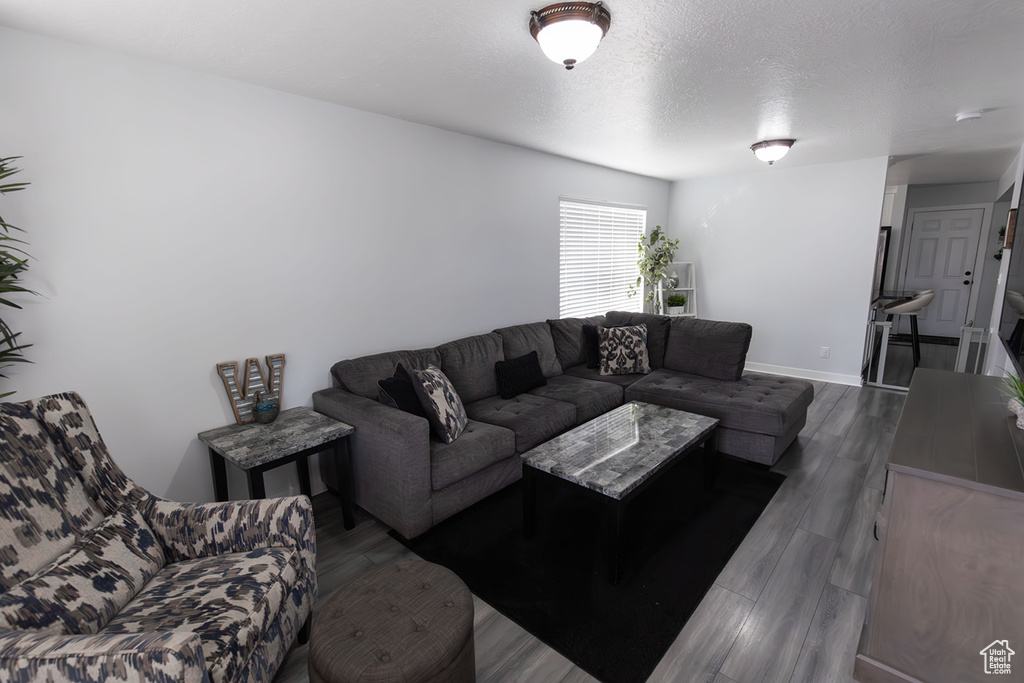 Living area with wood finished floors, baseboards, and a textured ceiling
