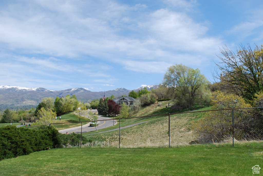 View of property's community with a mountain view, fence, and a yard