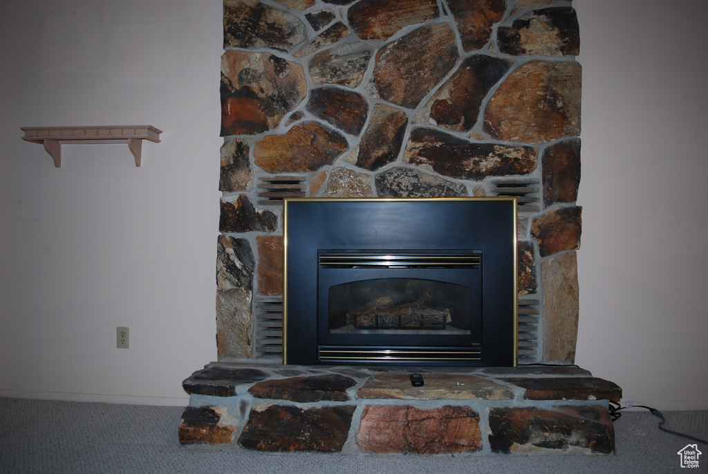Detailed view of carpet flooring and a stone fireplace