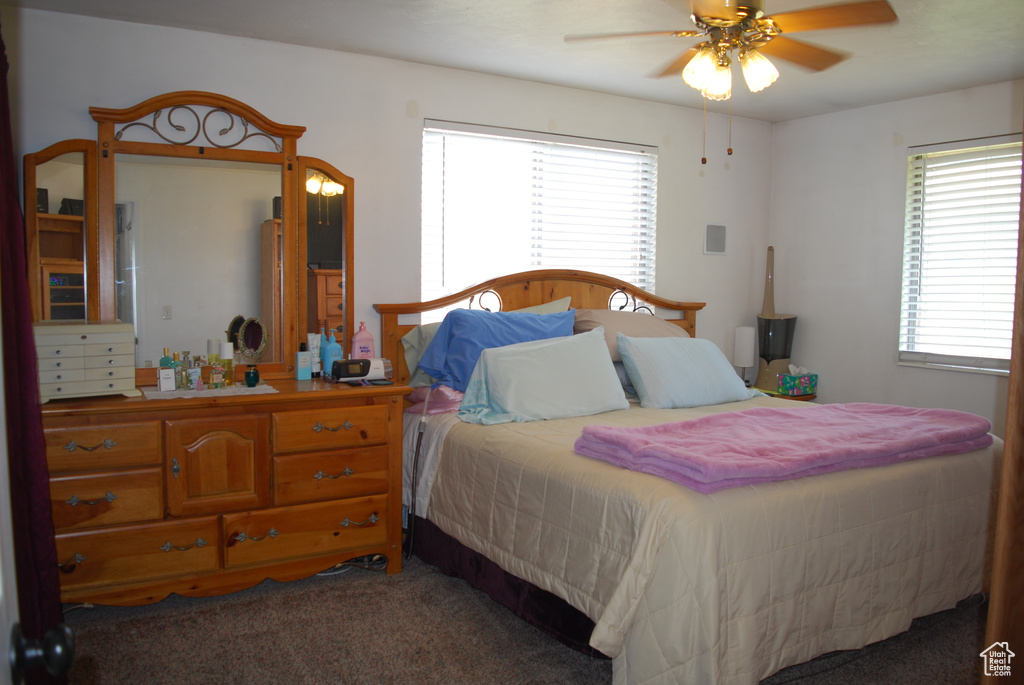 Carpeted bedroom with a ceiling fan